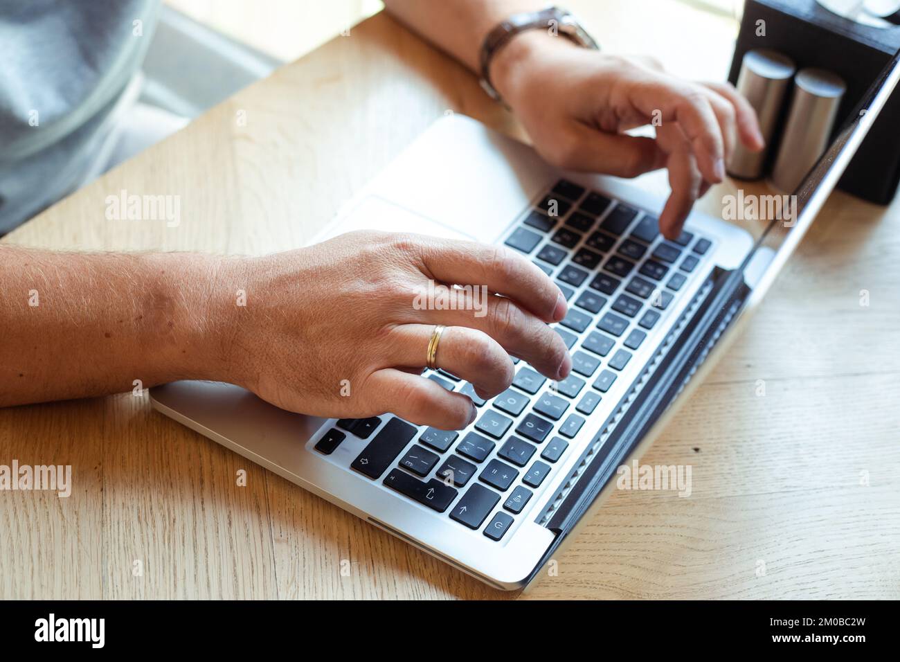 Unrecognizable, cropped man hands working on laptop in light Internet cafe. Business finance industry and IT, marketing Stock Photo