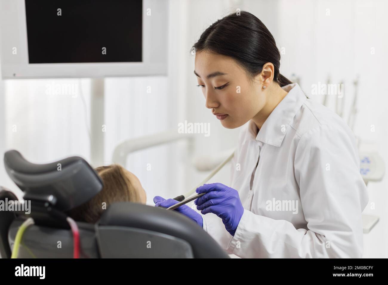 Children's dentistry, pediatric dentistry. Young beautiful asian female