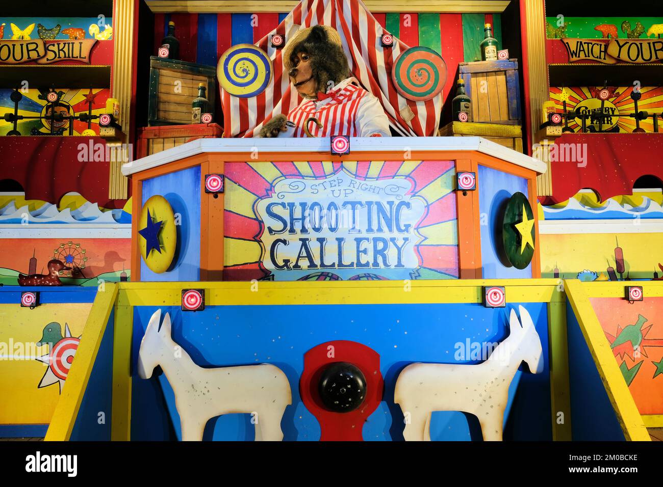 Animal themed shooting gallery with animatronic bear; amusement park game with guns and rifles for shooting animals. Stock Photo