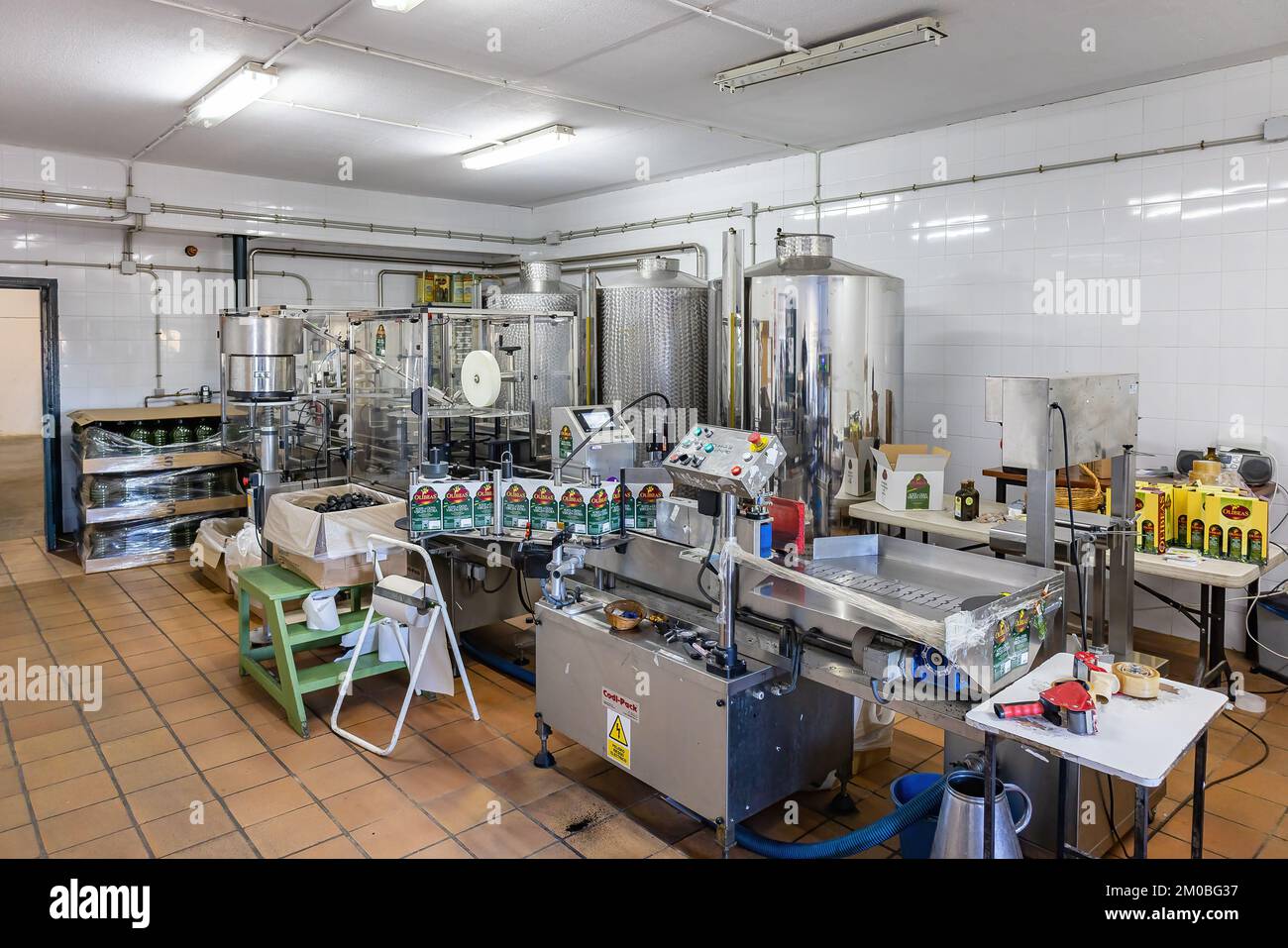 Huelva, Spain - December 4, 2022: Bottling and labeling machine inside of a modern olive oil mill. Extra virgin olive oil factory brand Olibeas in the Stock Photo