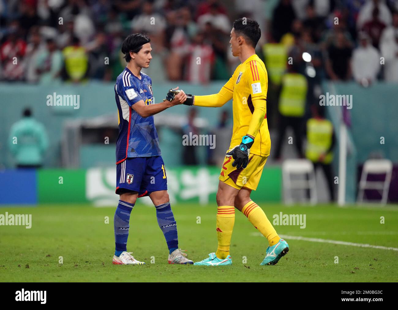 Japan’s Takumi Minamino with goalkeeper Shuichi Gonda after missing in the penalty shoot out during the FIFA World Cup Round of Sixteen match at the Al Janoub Stadium in Al-Wakrah, Qatar. Picture date: Monday December 5, 2022. Stock Photo