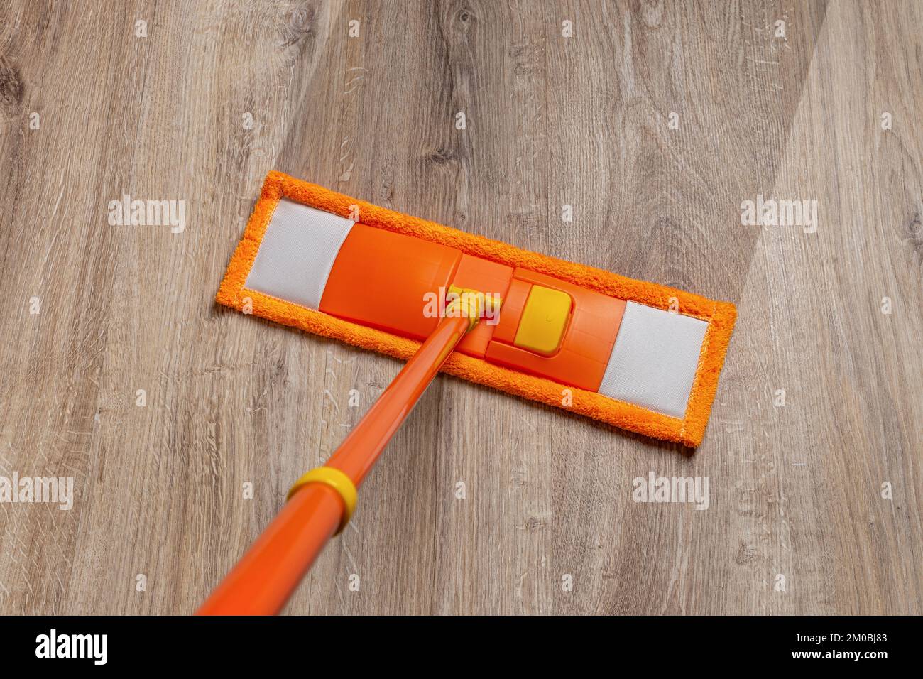 Wiping dirty wooden floor by wet wiper mop, housework. Topview Stock Photo  - Alamy