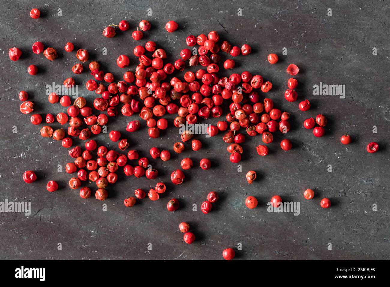 Top view of red peppercorns on black stone with copy space. Macro shot Stock Photo Alamy