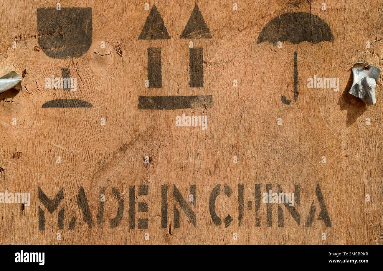 Made in China printed on wooden goods box, symbol for fragile goods, protect from water, handle with care  / Holzkiste mit Aufschrift Made in China Stock Photo