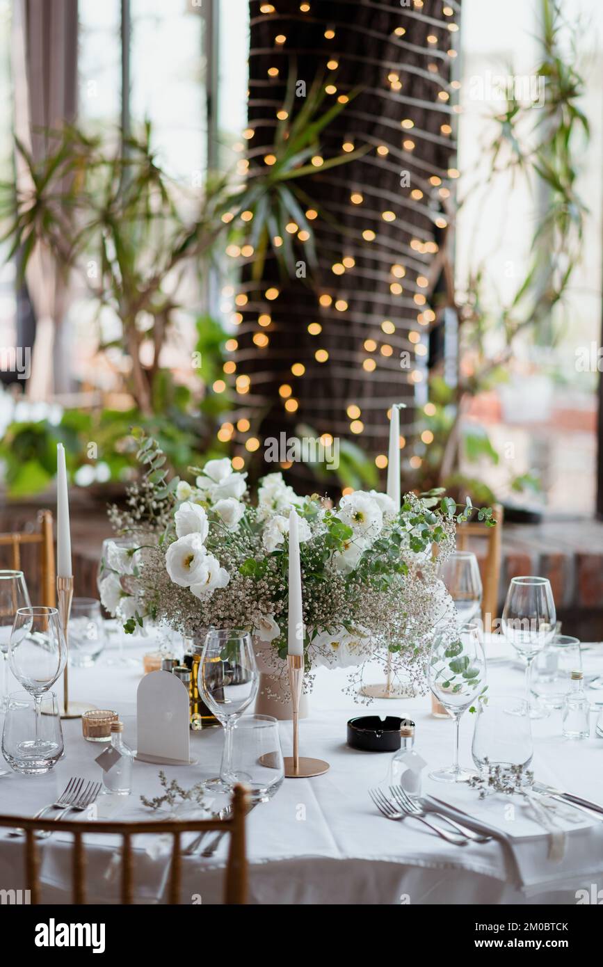 A beautifully decorated table with white flowers and candles, vertical ...