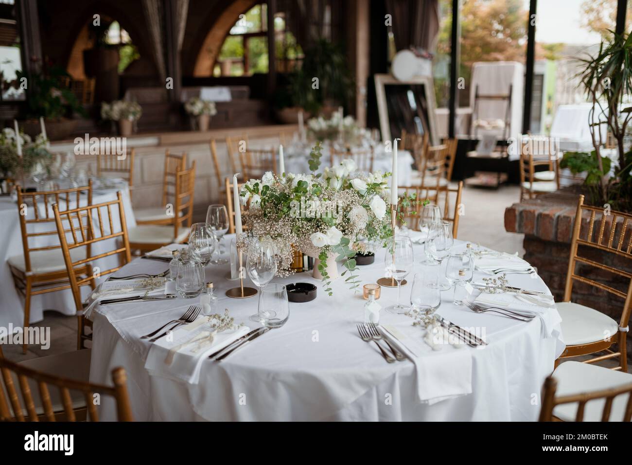 A beautifully decorated table with white flowers bouquet and candles ...