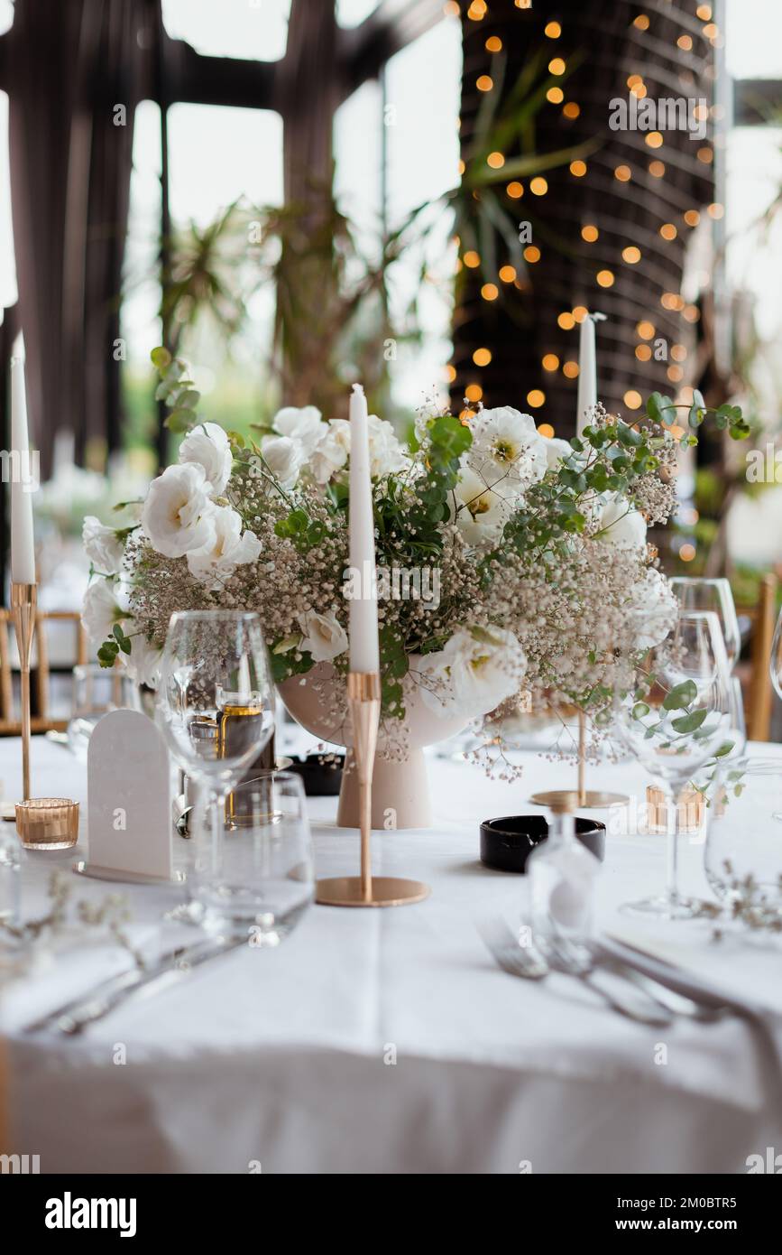 A beautifully decorated table with white flowers and candles, vertical ...