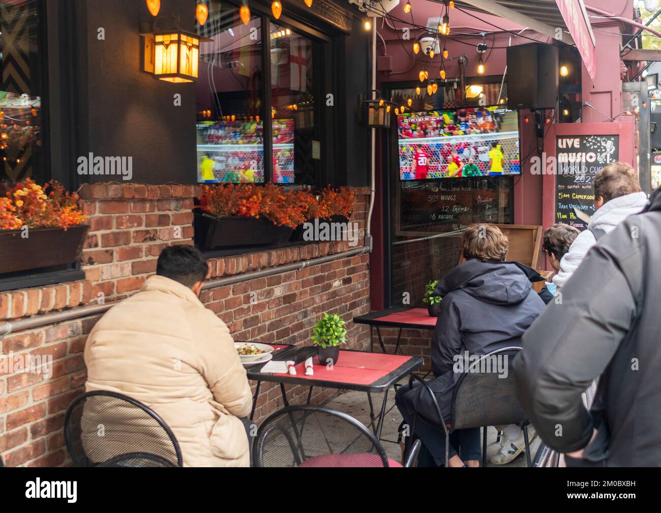 Sports fans watch the FIFA World Cup football (soccer) outside of a bar
