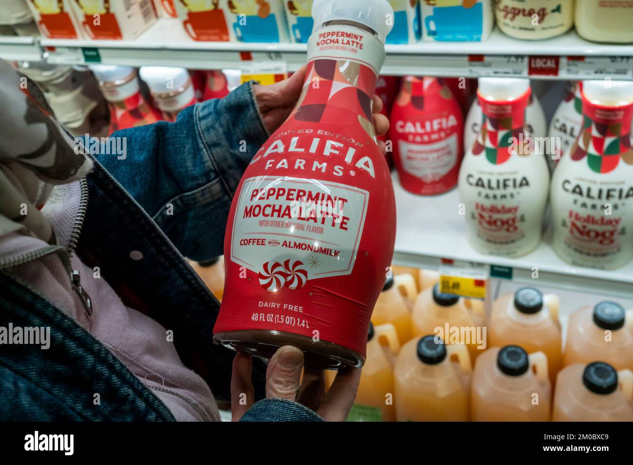 A shopper chooses a bottle of Christmas themed Peppermint Mocha Latte, coffee with almond milk, from Califia Farms in a Whole Foods supermarket in New York on Monday, November 28, 2022. The U.S. Federal Reserve Bank reported that it will be difficult to bring inflation down without a recession. (© Richard B. Levine) Stock Photo