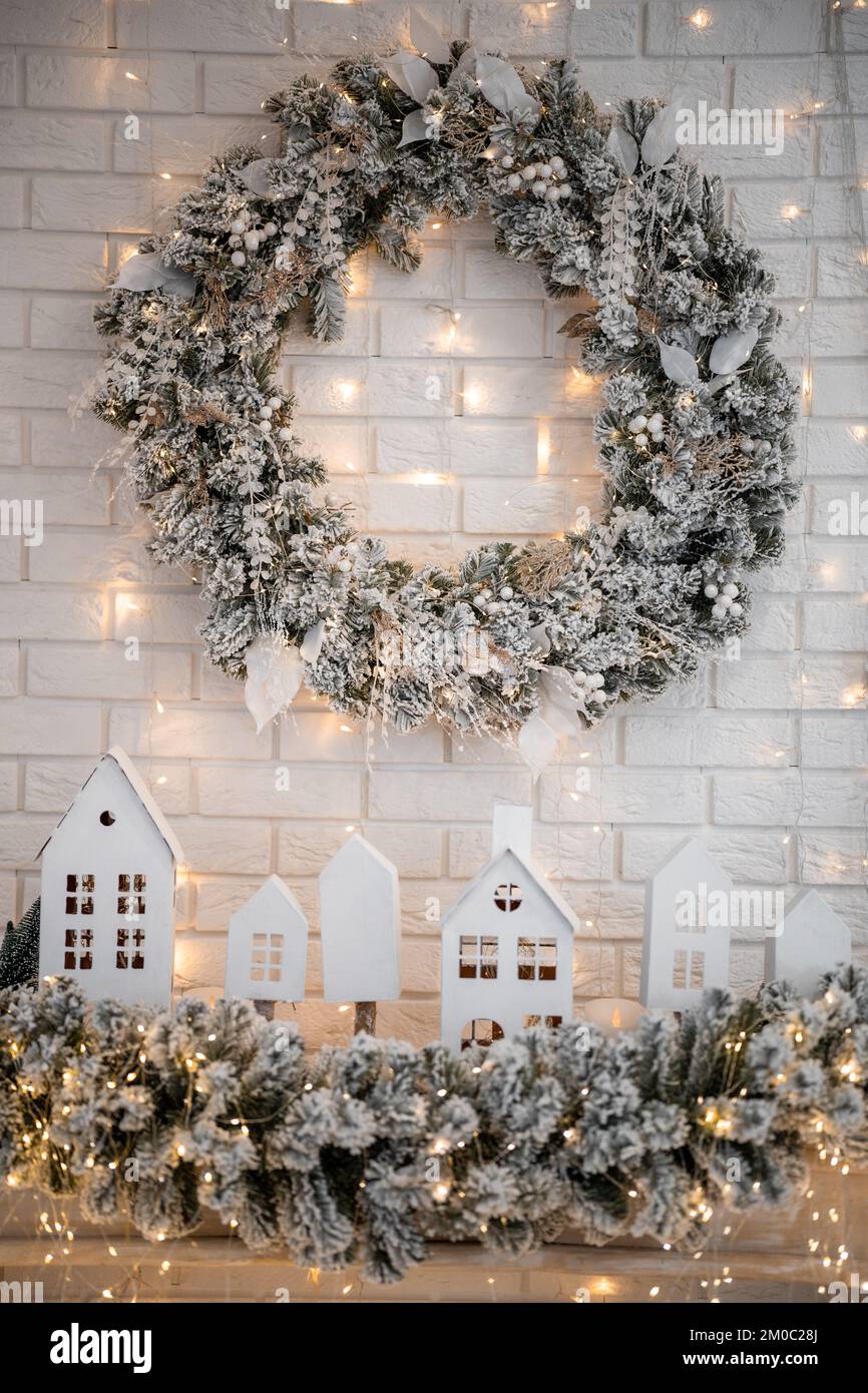 A traditional bright Christmas wreath hanging over the fireplace, on a