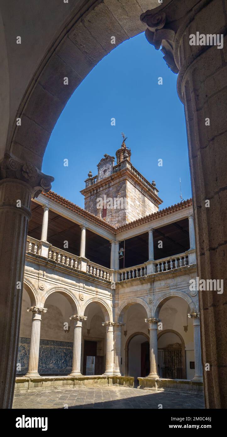Ornate medieval arches and behind the cloister and the blue azulejo panels that cover the walls of the cloister of the Cathedral of Santa María de la Stock Photo
