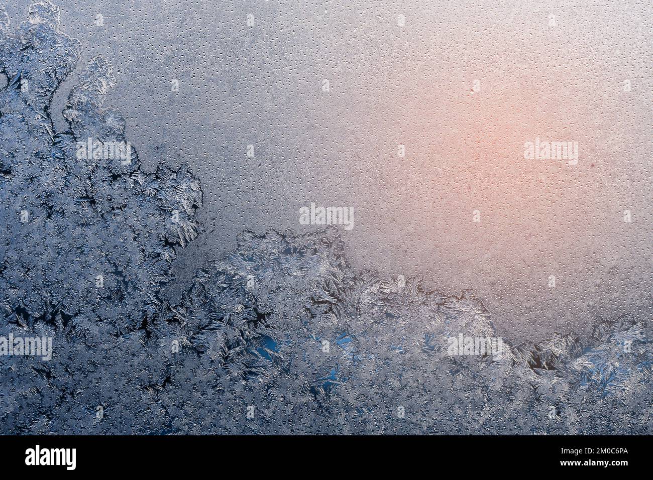Frozen surface with icy pattern on window glass in cold winter day Stock Photo