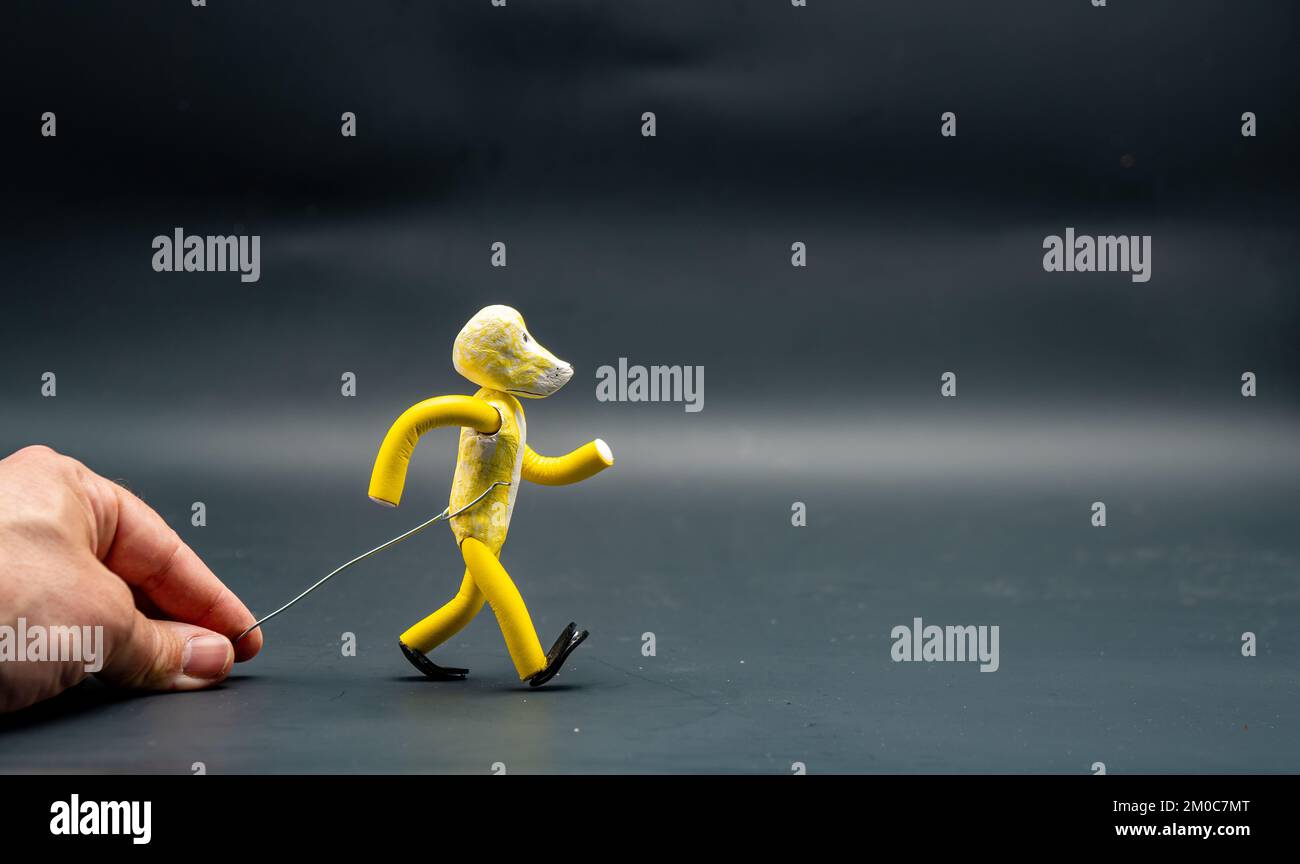 Stopmotion process of walking. First step. Man's hand holding with an  aluminum wire a figure made with yellow modeling paste starting the process  of w Stock Photo - Alamy