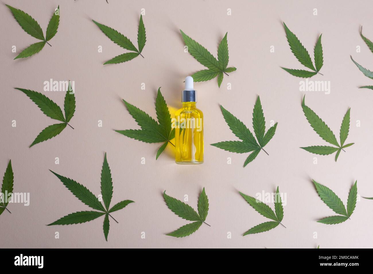 Various glass bottles with CBD oil, THC tincture and hemp leaves on a marble background. Flat lay, minimalism. Cosmetics CBD oil. Stock Photo