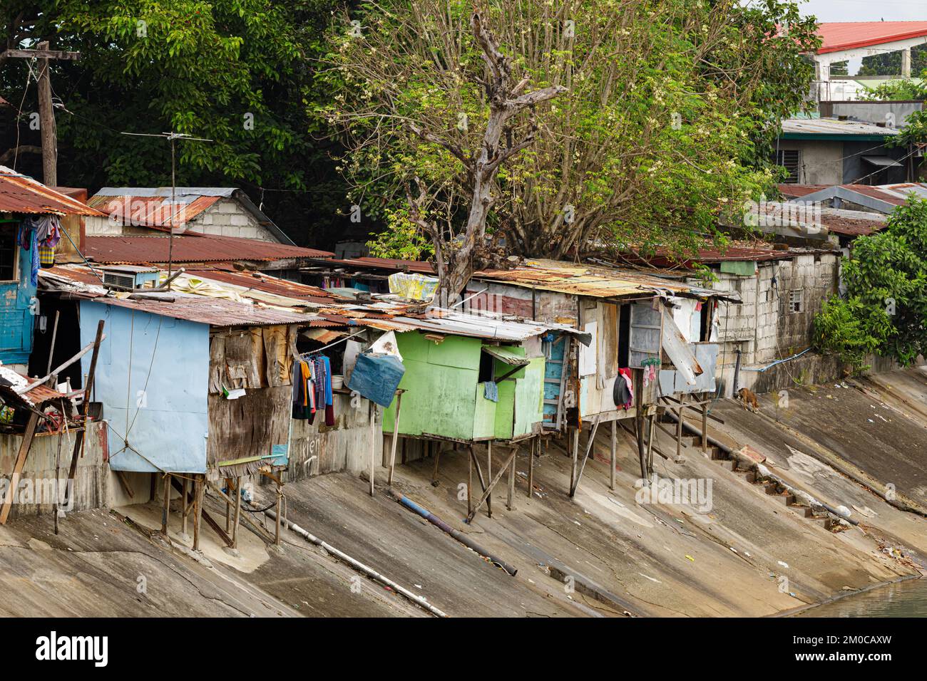 Poor people living in poverty along the canals of Manila Philippines with copy space Stock Photo