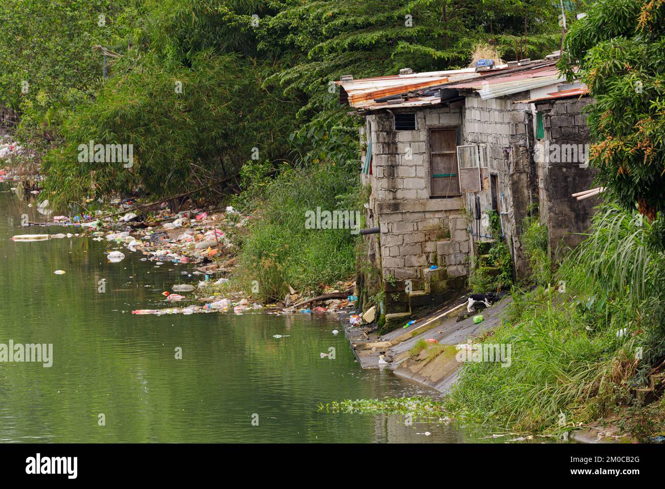 Poor people living in poverty along the canals of Manila Philippines with copy space Stock Photo