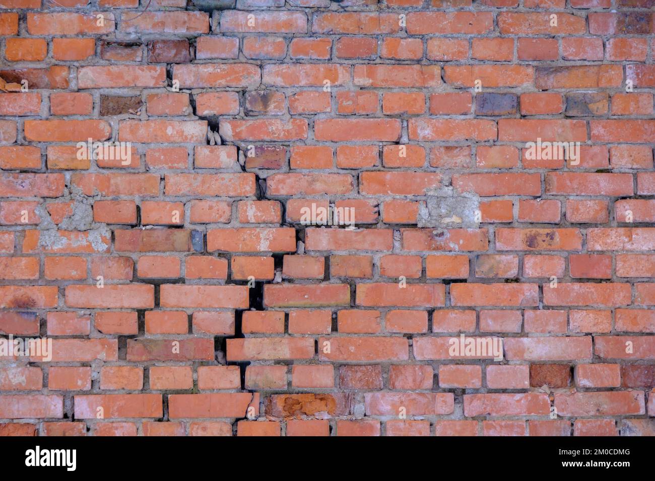 Cracked red brick wall. Brick wall background. Stock Photo
