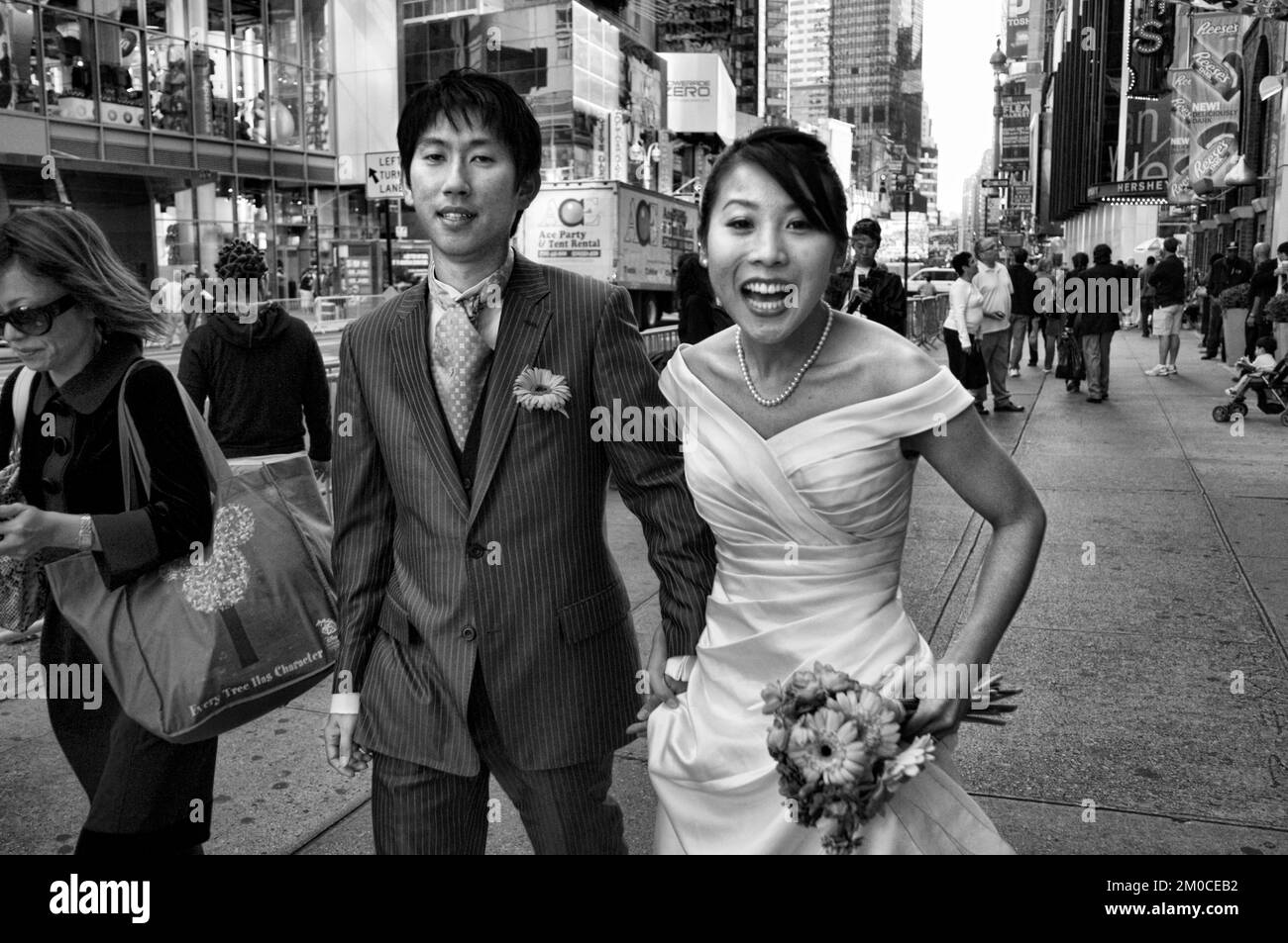 A newly married Asian couple celebrating their honeymoon in the area of Times Square, Manhattan, New York, USA Stock Photo