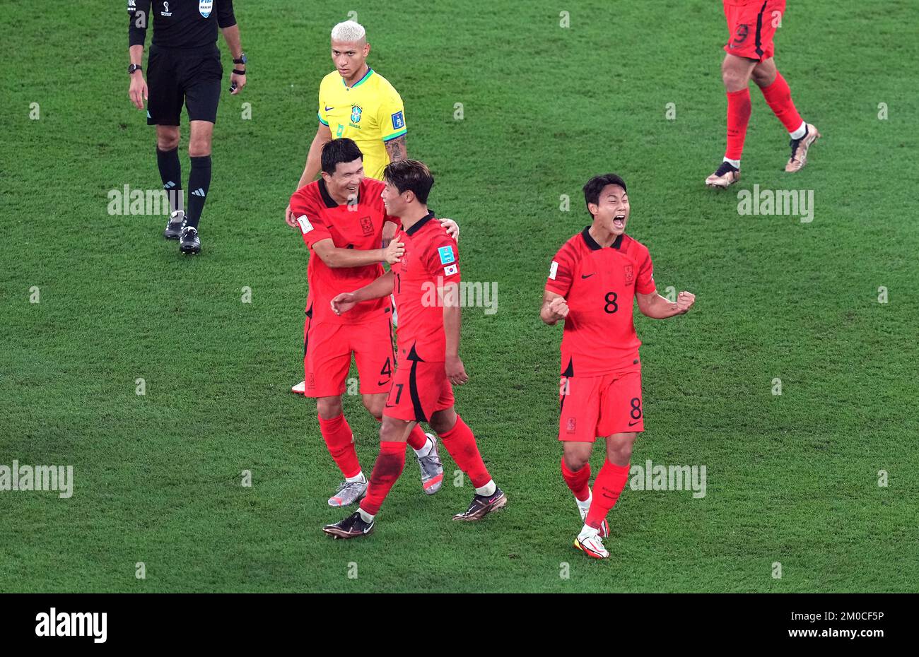 South Korea's Paik Seung-ho (centre) celebrates scoring their side's first goal of the game with team-mates as Brazil's Richarlison looks frustrated during the FIFA World Cup Round of Sixteen match at Stadium 974 in Doha, Qatar. Picture date: Monday December 5, 2022. Stock Photo