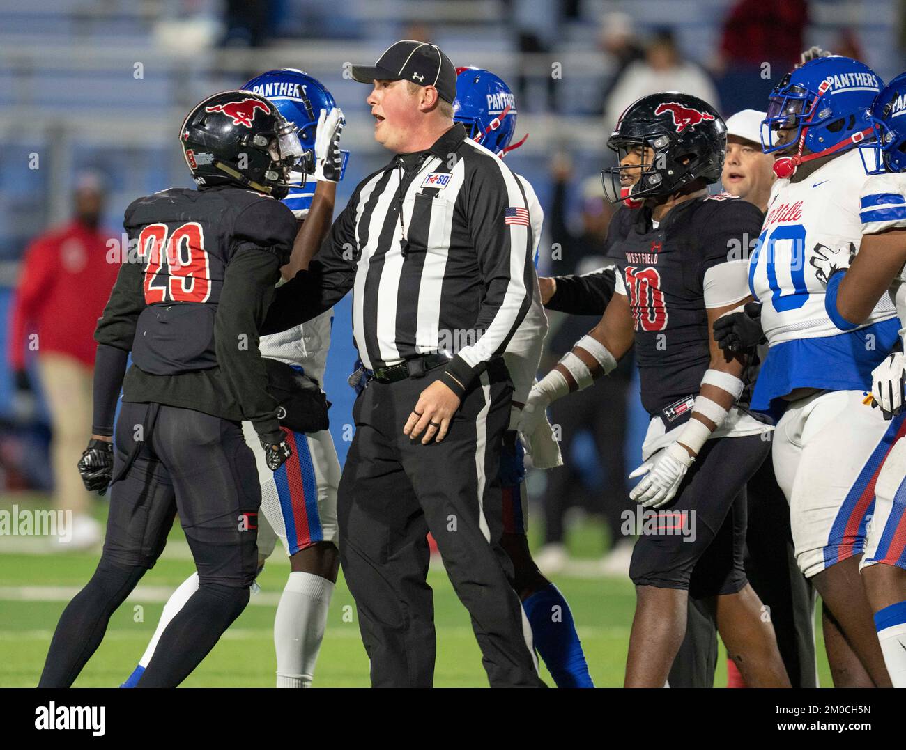 Georgetown Texas USA, December 3 2022: Referee tries to break up altercation between members of rival high school football teams at the end of a University Scholastic League (UIL) quarter-final playoff football game in central Texas. ©Bob Daemmrich Stock Photo