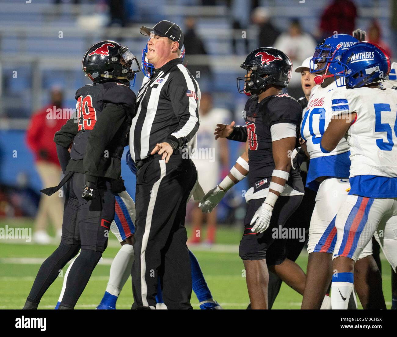 Georgetown Texas USA, December 3 2022: Referee tries to break up altercation between members of rival high school football teams at the end of a University Scholastic League (UIL) quarter-final playoff football game in central Texas. ©Bob Daemmrich Stock Photo