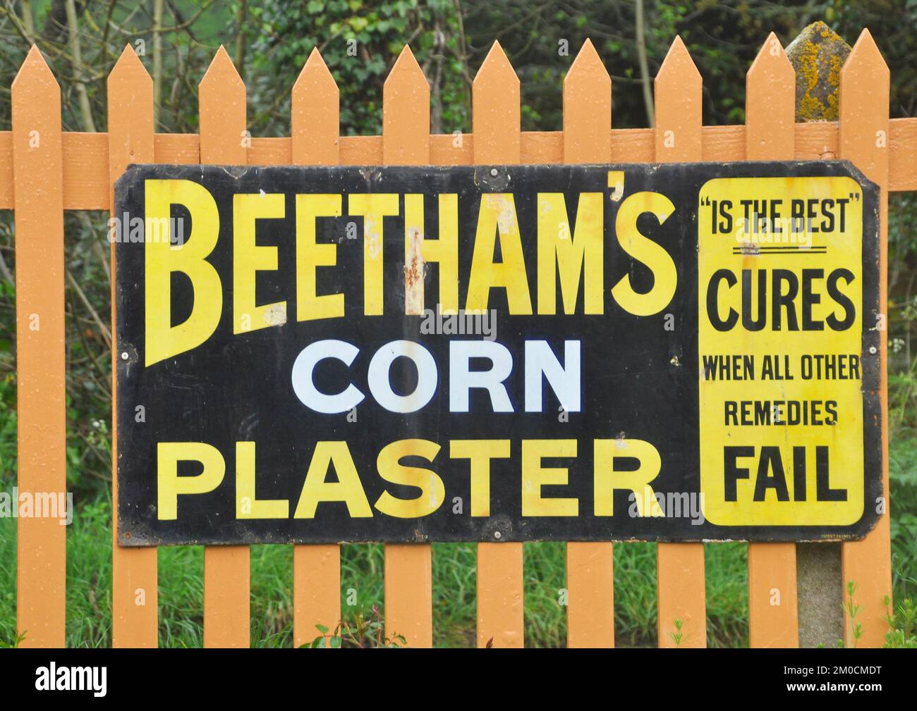 Enamelled metal sign, advertising Beettham's corn plasters photographed at Bishops Lydeard station on the West Somerset railway in Somerset,England, U Stock Photo