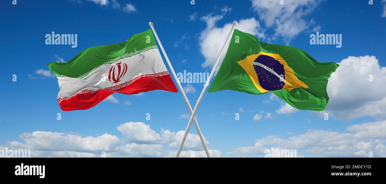 two crossed flags Brazil and Iran waving in wind at cloudy sky. Concept ...