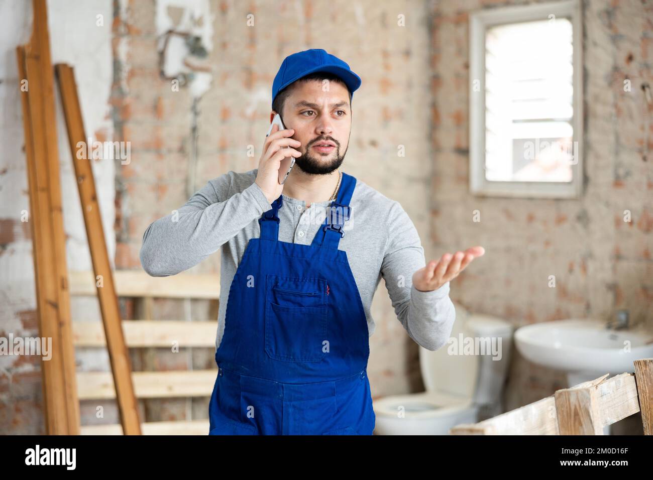 Builder talking on phone at construction site Stock Photo
