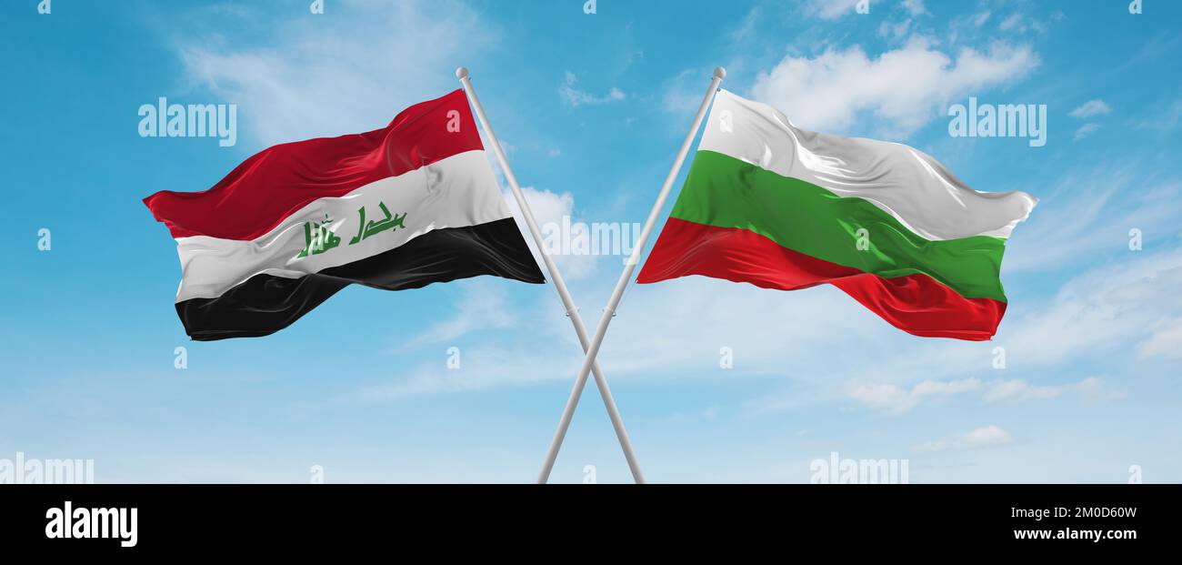 two crossed flags Bulgaria and Iraq waving in wind at cloudy sky ...