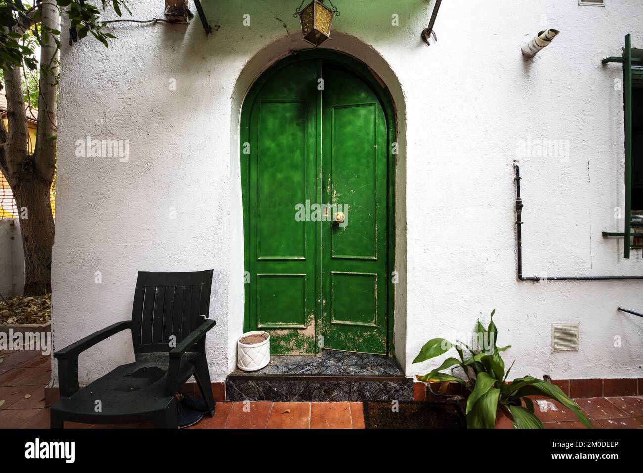 Exterior area of a detached house with a green door in the shape of a ...