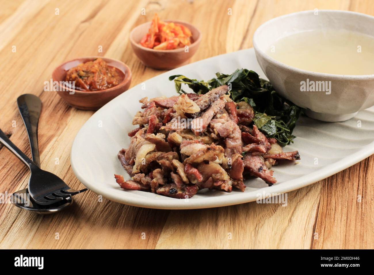Se'i Sapi or Beef Sei is Indonesia Traditional Smoked Beef, Served with Boiled Cassava Leaves and Sambal Luat or Sambal Matah. Typically Food from Nus Stock Photo