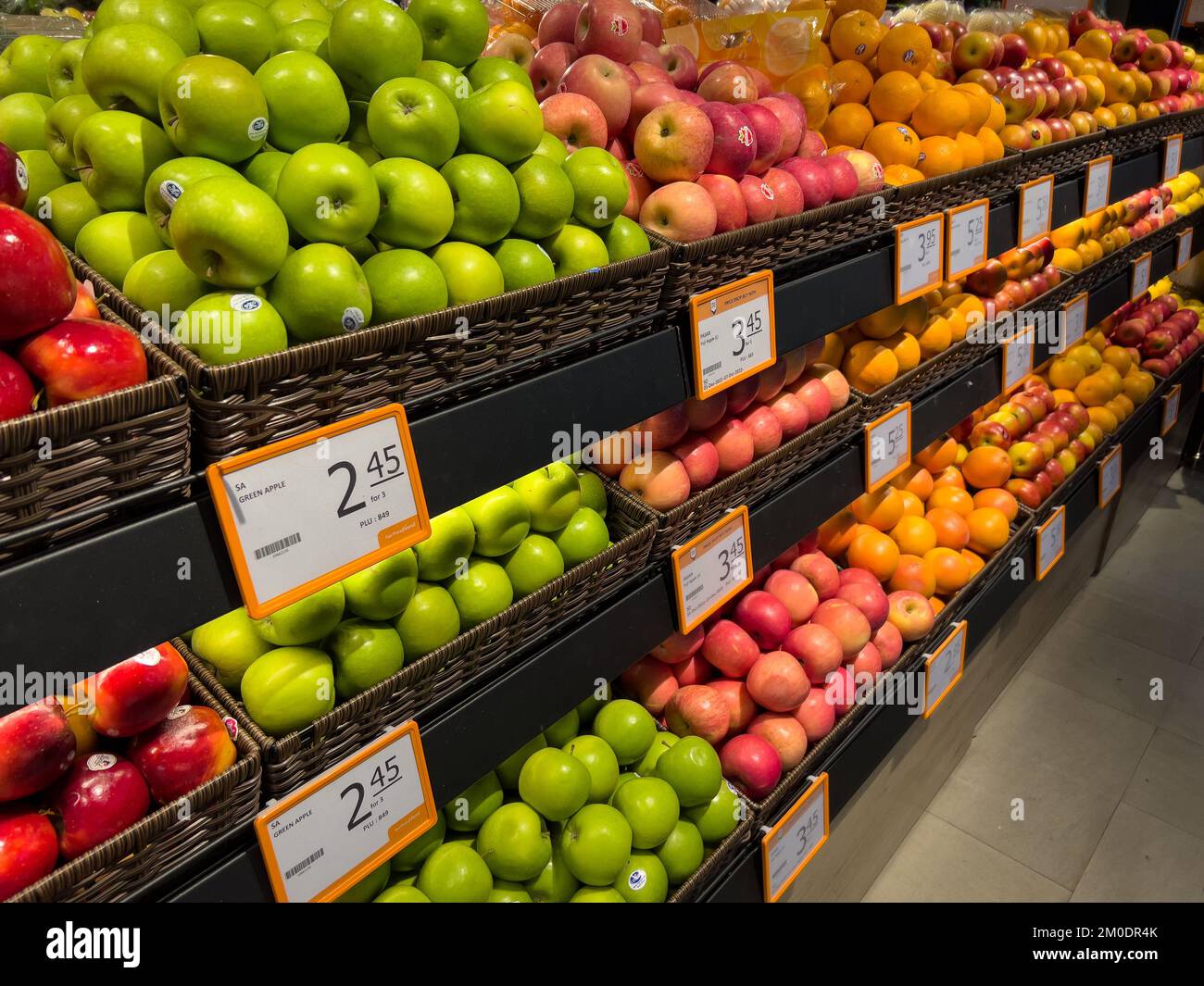 Diagonal angle of fresh fruits such as apples and oranges on the shelves for consumers to buy it in the supermarket. Stock Photo