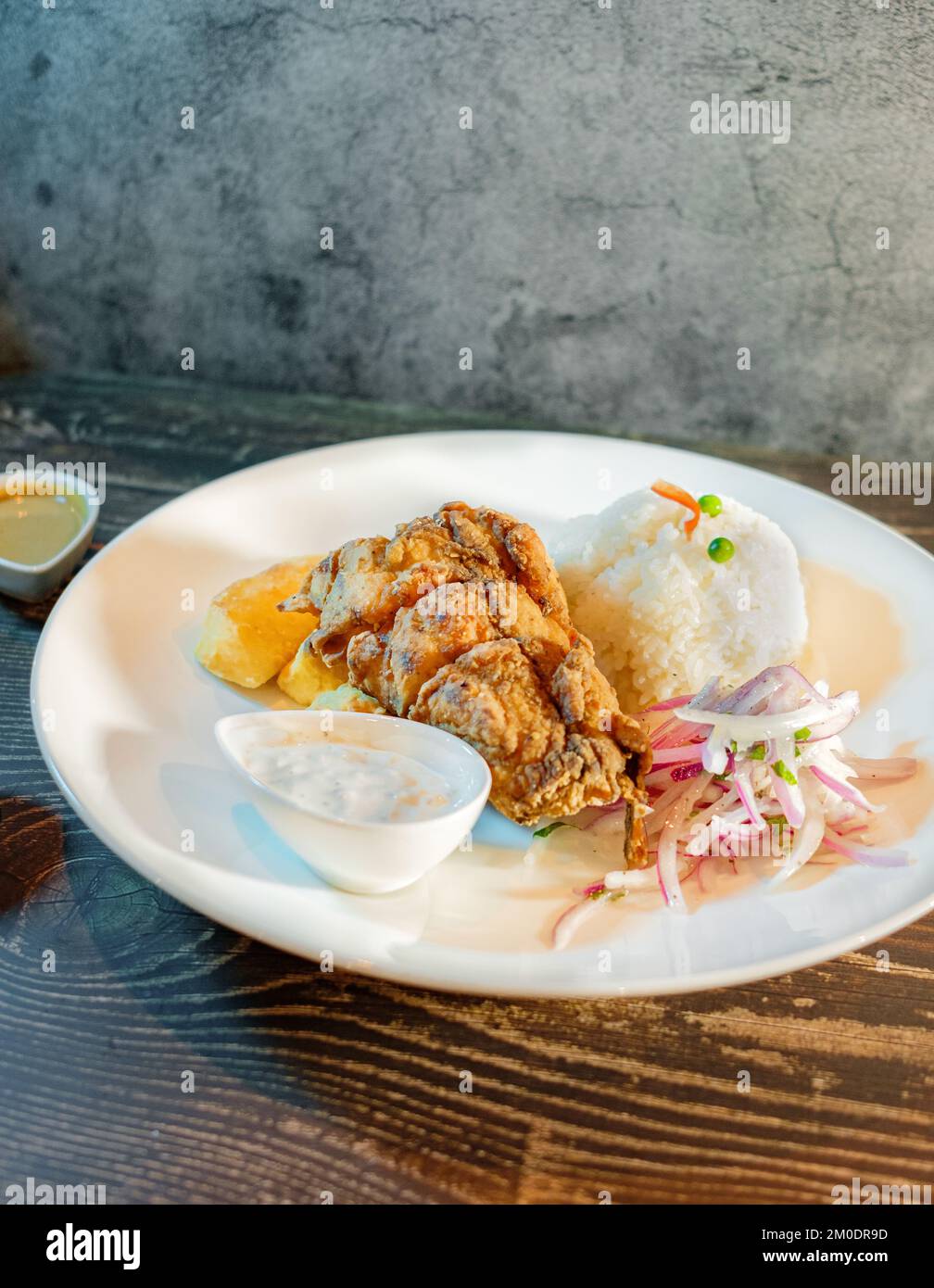 Fried fish filet with white rice, potatoes and salad Stock Photo