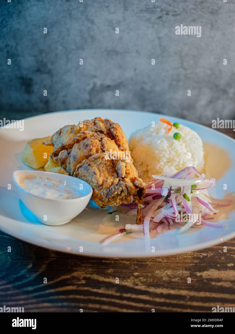 Fried fish filet with white rice, potatoes and salad Stock Photo