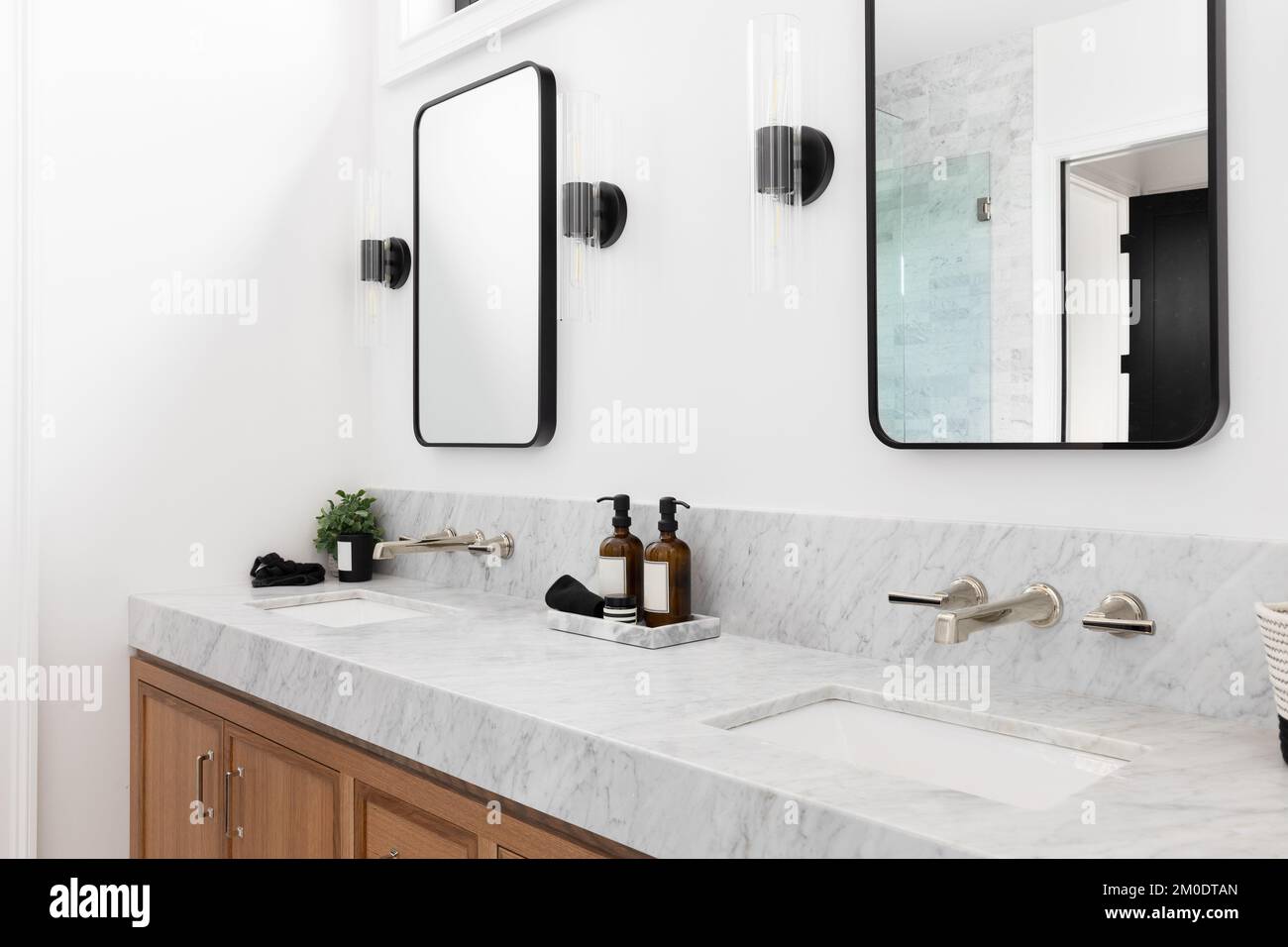 A cozy bathroom with a wood marble countertop, and sconces