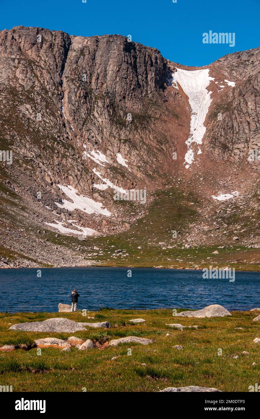 A photographer shooting and enjoying the beautiful scenery at Summit Lake on Mt. Evans in Colorado. Stock Photo