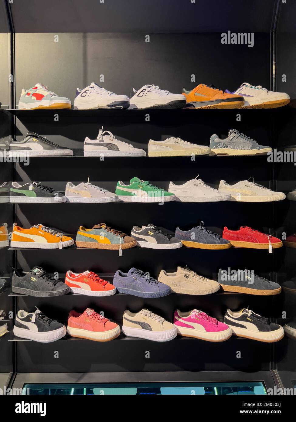Neat display of Puma shoes model on shelves for the customer to glance or admire the stylish design. Stock Photo
