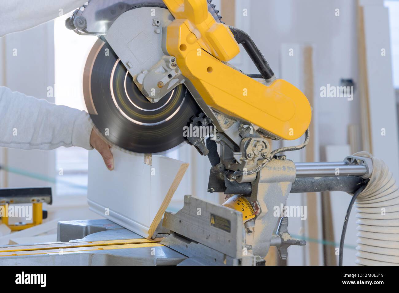 In order to finish wood moldings board, construction worker uses