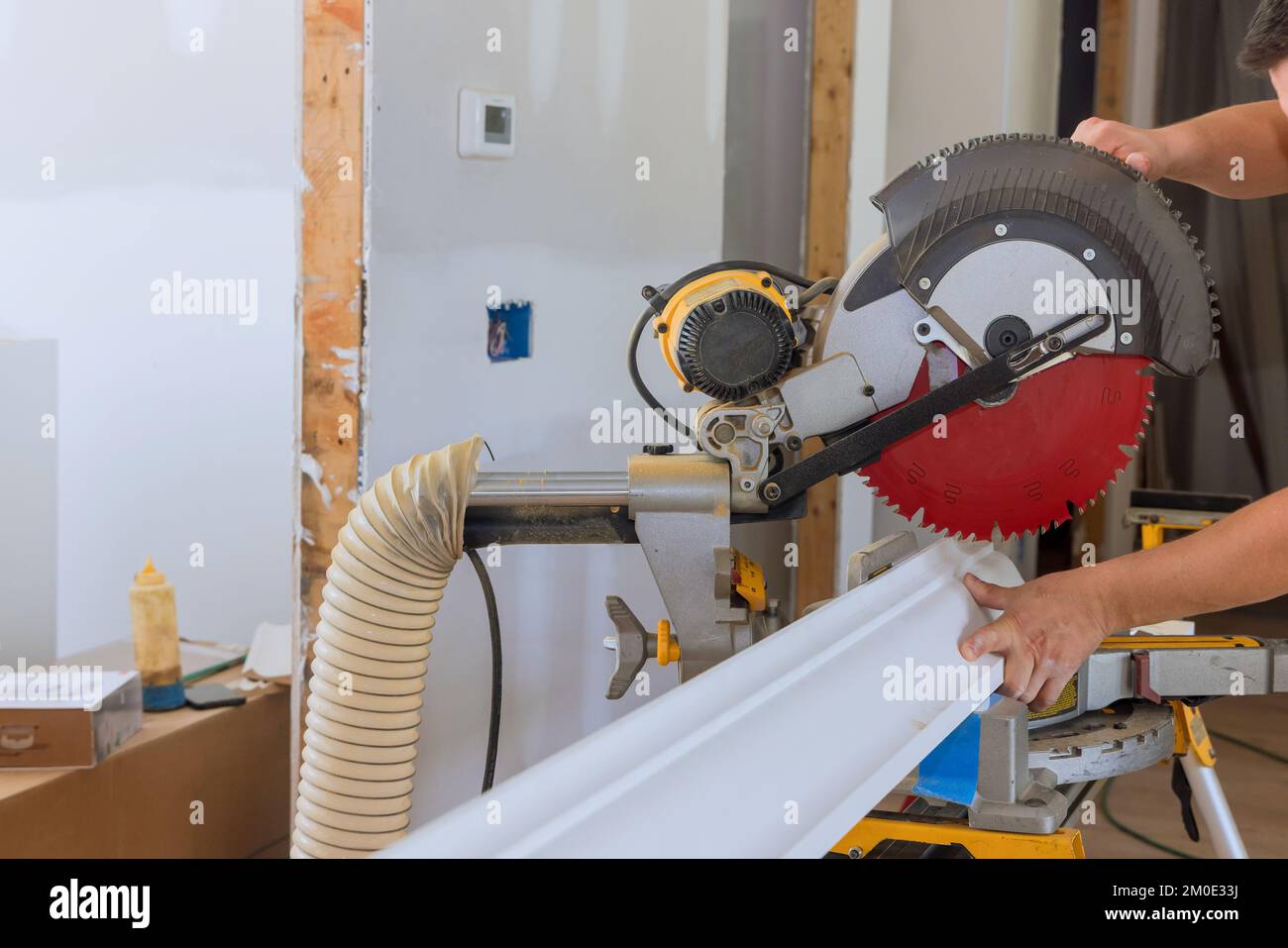 Construction worker cuts wood moldings board on circular saw finishing