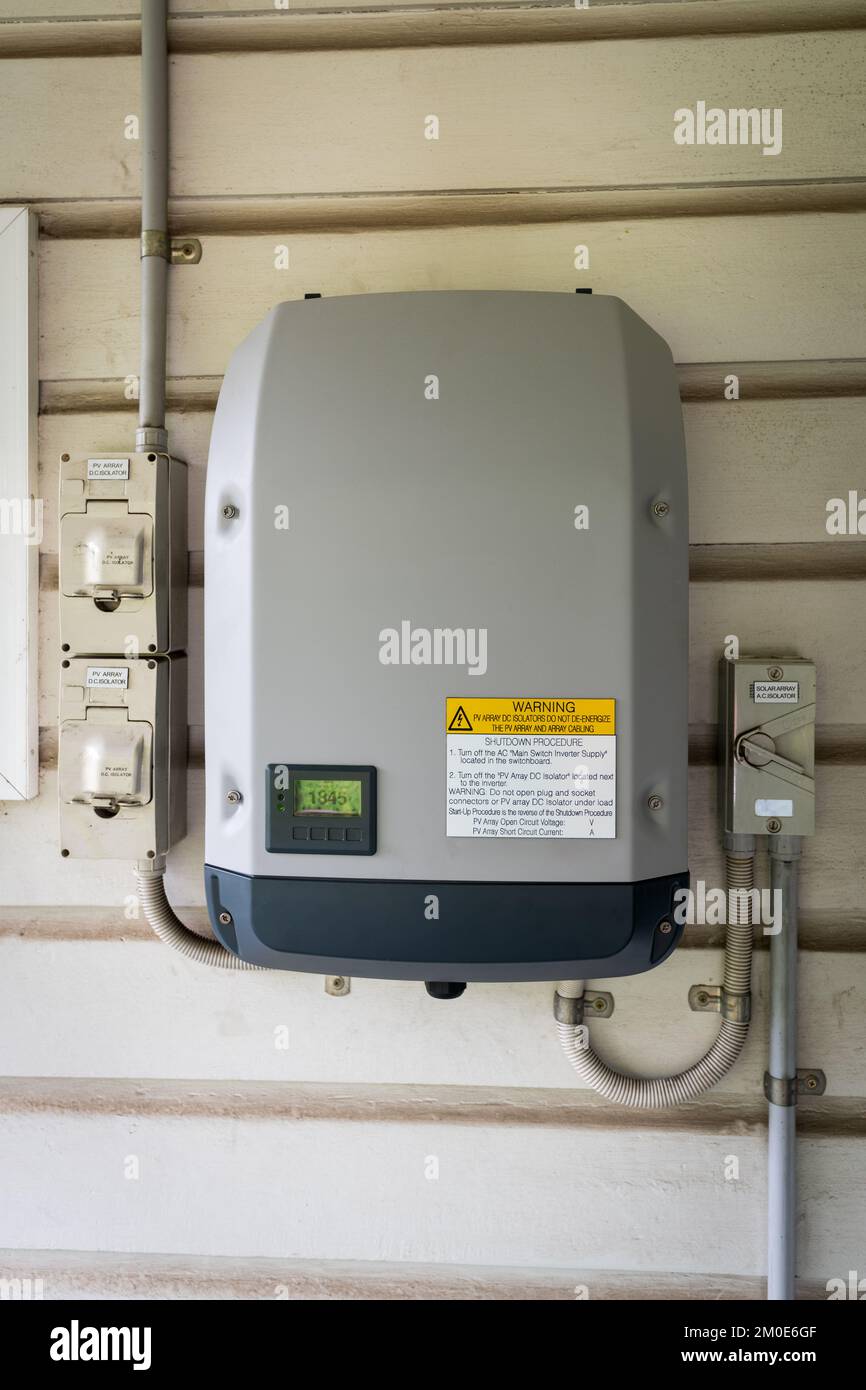 Solar power inverter mounted on side of a house, domestic system Stock Photo