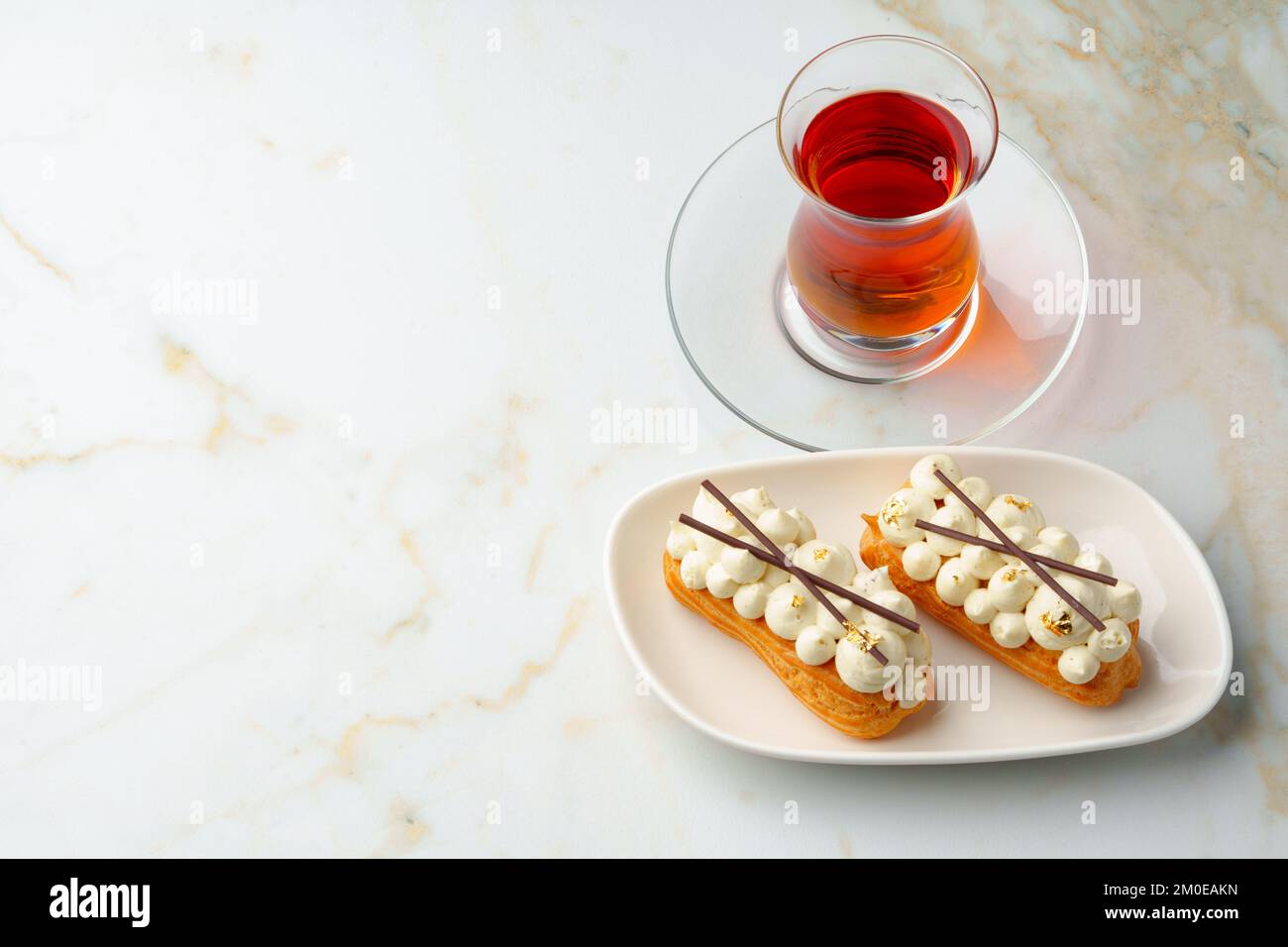 Two eclairs with white custard on whhite plate Stock Photo