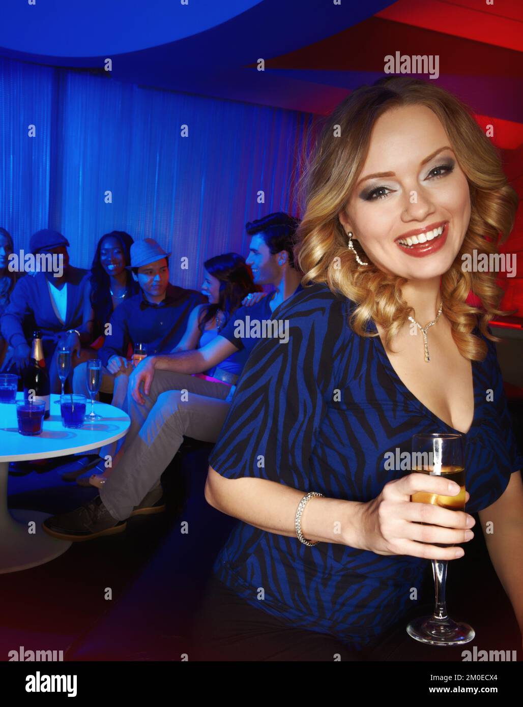 Loving the bubbly. A beautiful young woman enjoying drinks with her friends in the club. Stock Photo