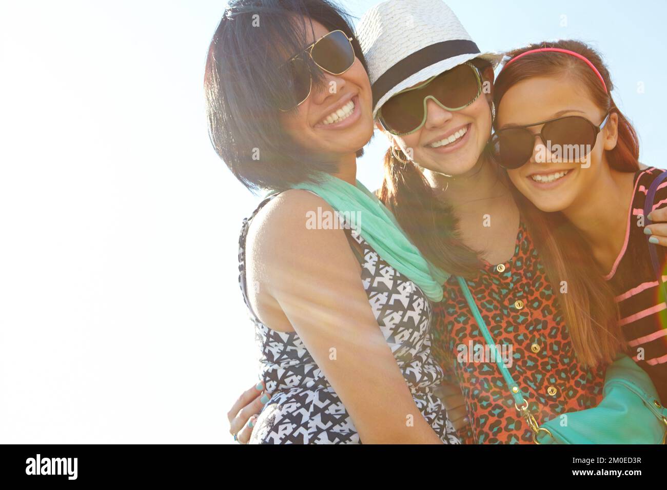 Friends are the most valuable possession. Closeup shot of a group of teenage girls smiling with their arms around each others shoulders. Stock Photo