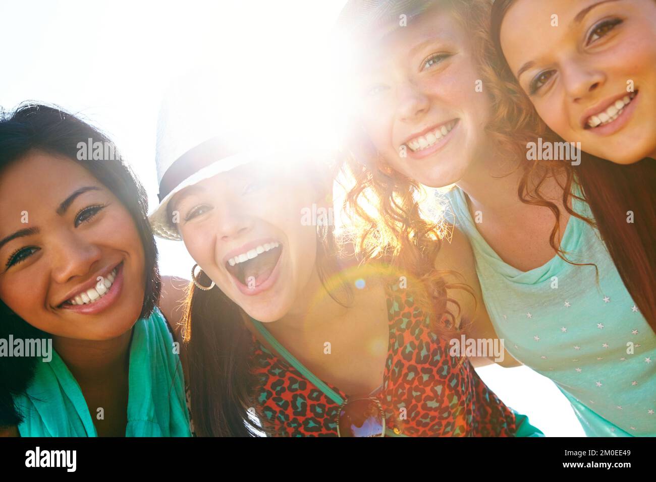 Friends, fun and summer sun. Closeup shot of a group of teenage girls smiling with their arms around each others shoulders. Stock Photo