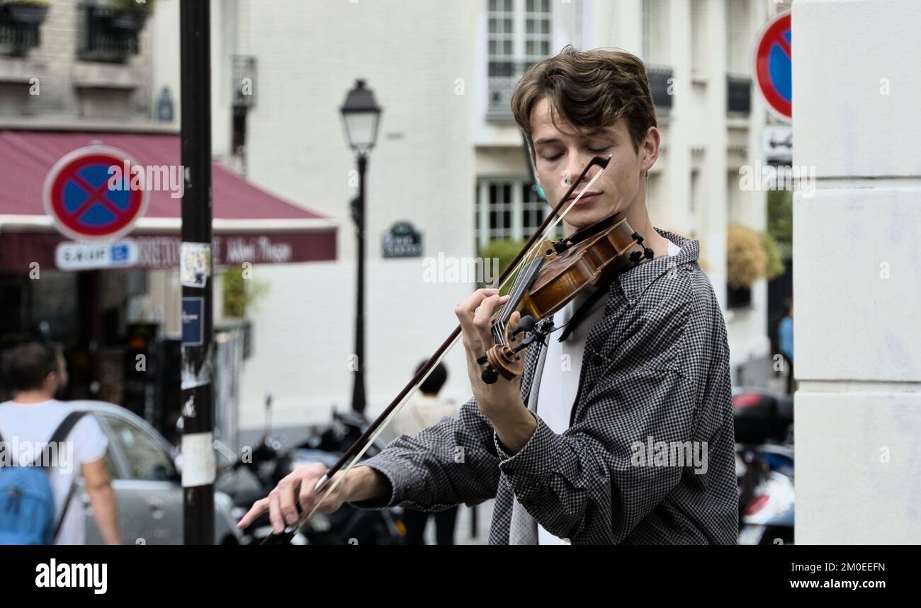 A young violinist playing on the side walk in Paris Stock Photo