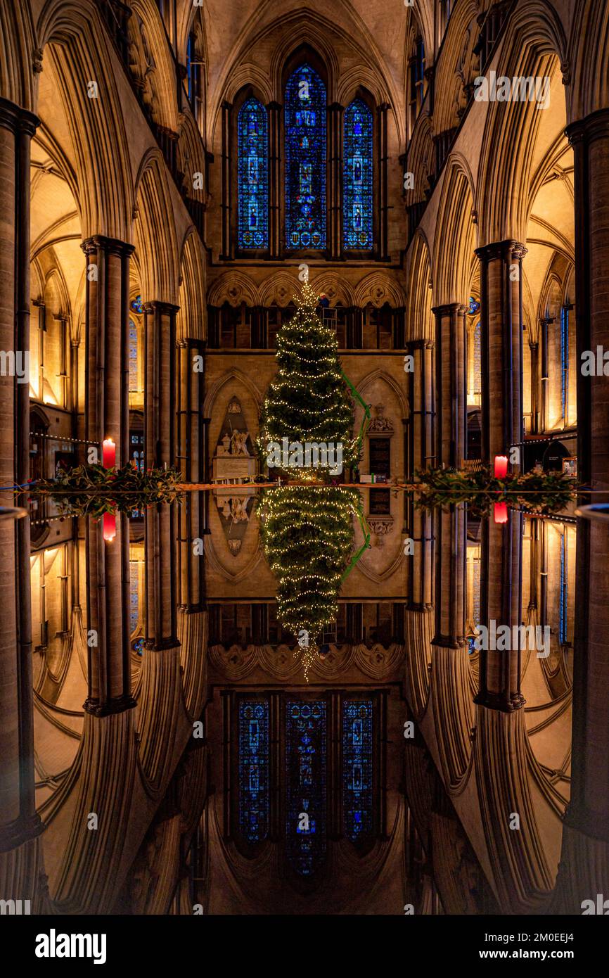 Richard Pike, Salisbury Cathedral's ecclesiastical joiner, places decorations on the 32ft Norway Spruce Christmas from Longleat Forest, as it is installed inside the cathedral's nave. Picture date: Monday December 5, 2022. Stock Photo