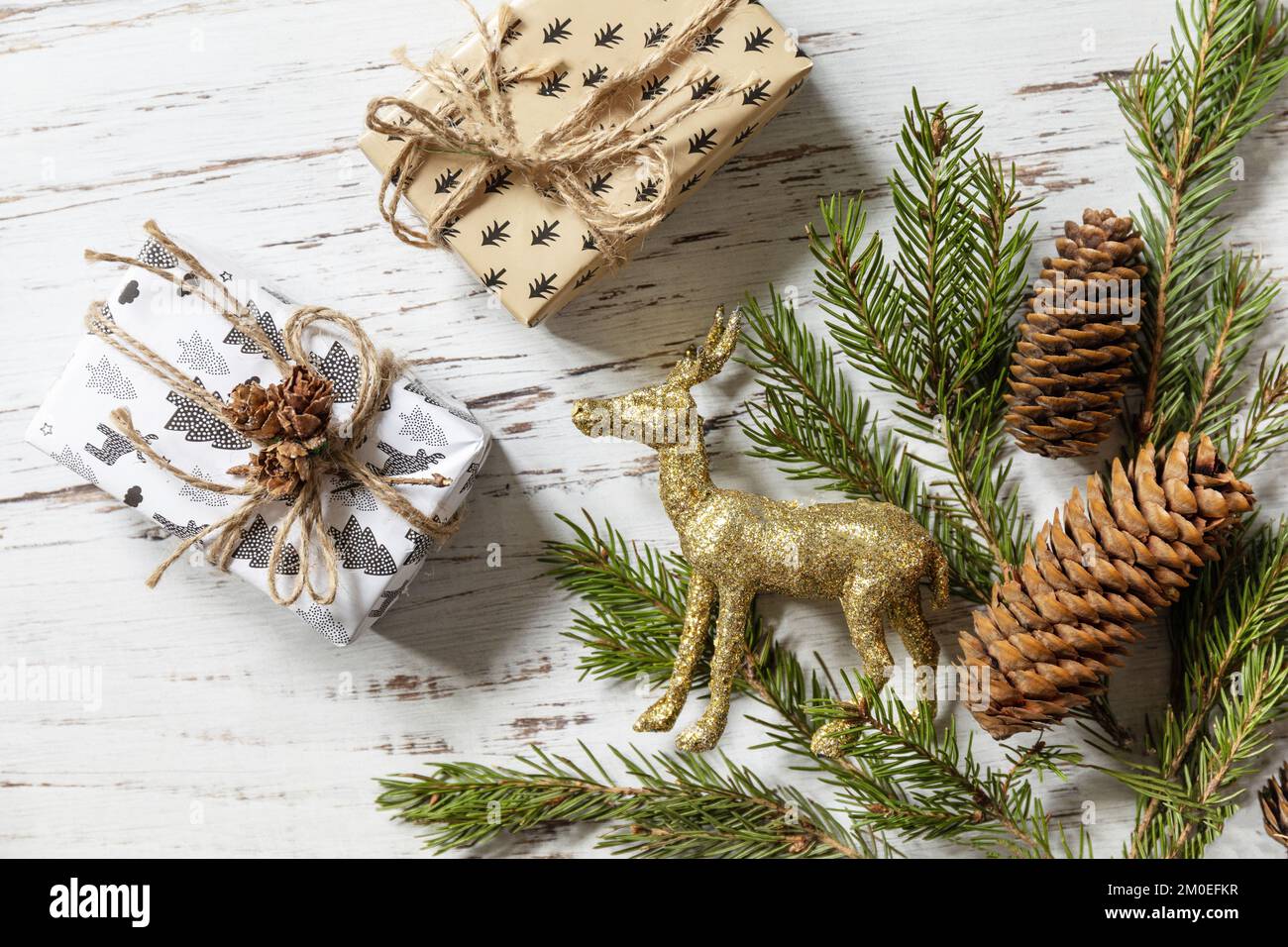 Christmas gold decor, christmas deer, fir tree twigs and gifts box on a  white wood background. View from above Stock Photo - Alamy