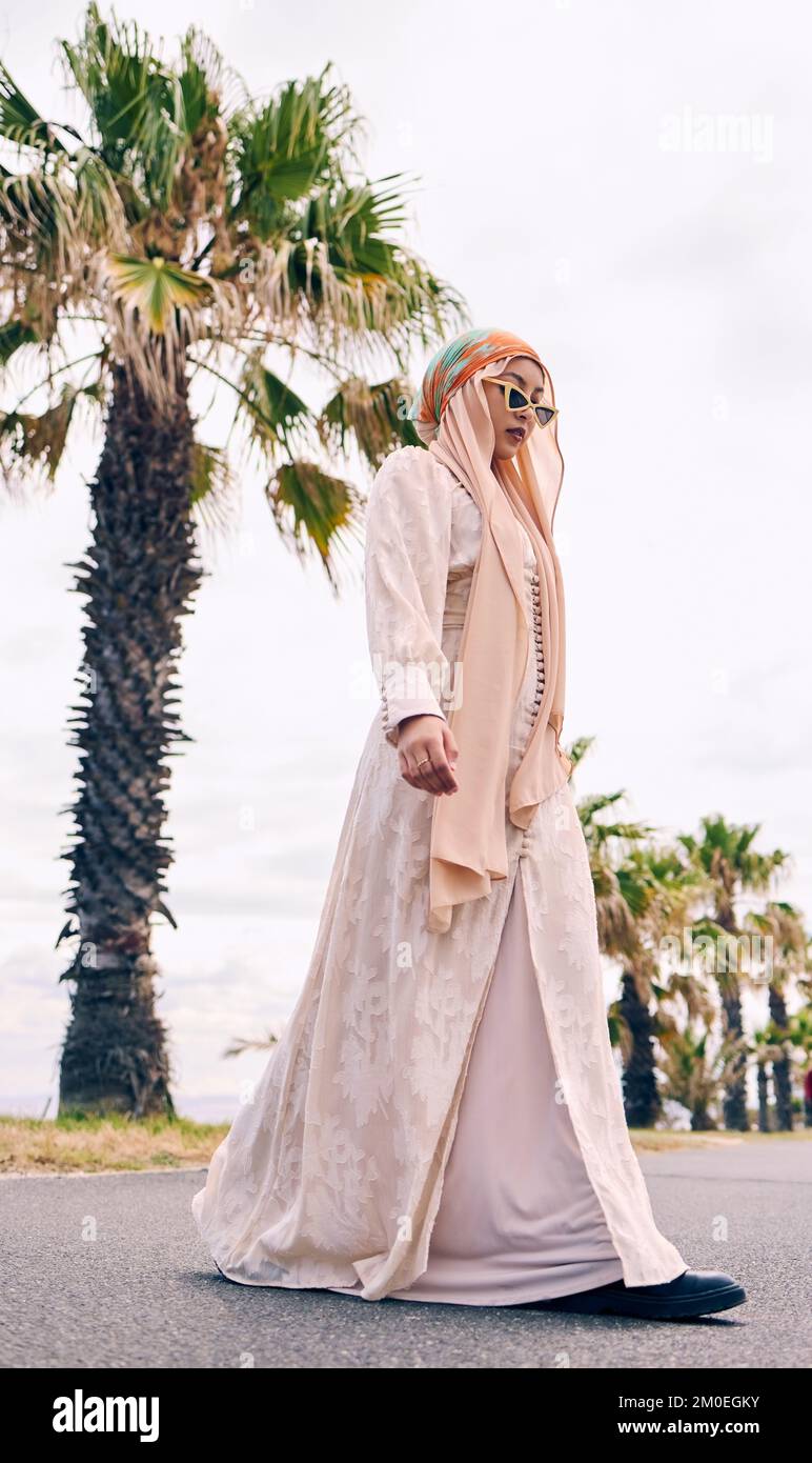 Beautiful young arab woman posing outdoors in a headscarf. Attractive female muslim wearing a hijab posing outside. Shes all about style and fashion Stock Photo