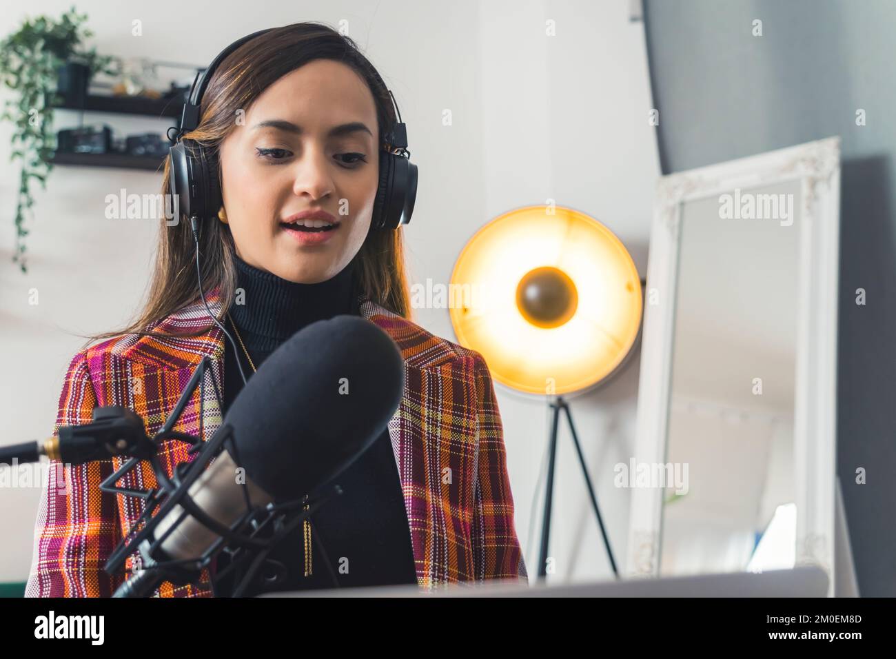 LatinAmerican radio host woman speaking in a microphone and reading