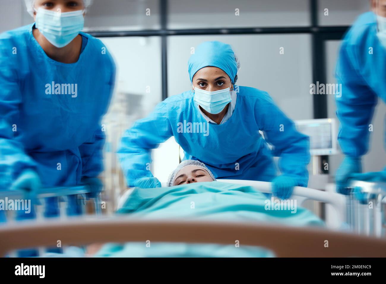 Surgeon, bed and rush in a hospital for emergency operation in the er with a sick patient. Surgery team, pushing sleeping woman and fast hospital bed Stock Photo